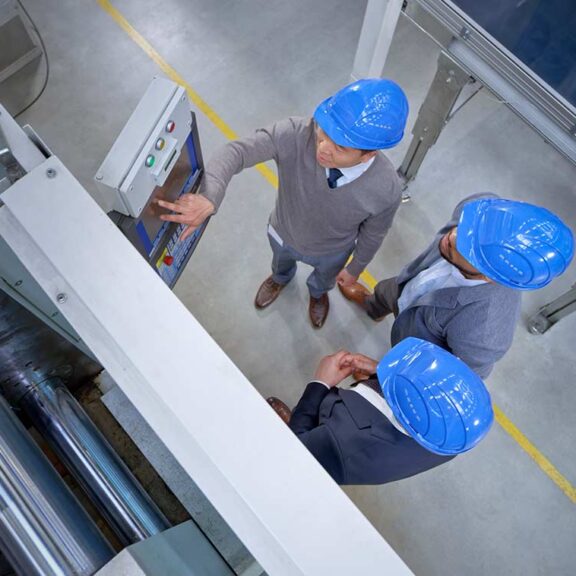 Manager and engineers examining control panel